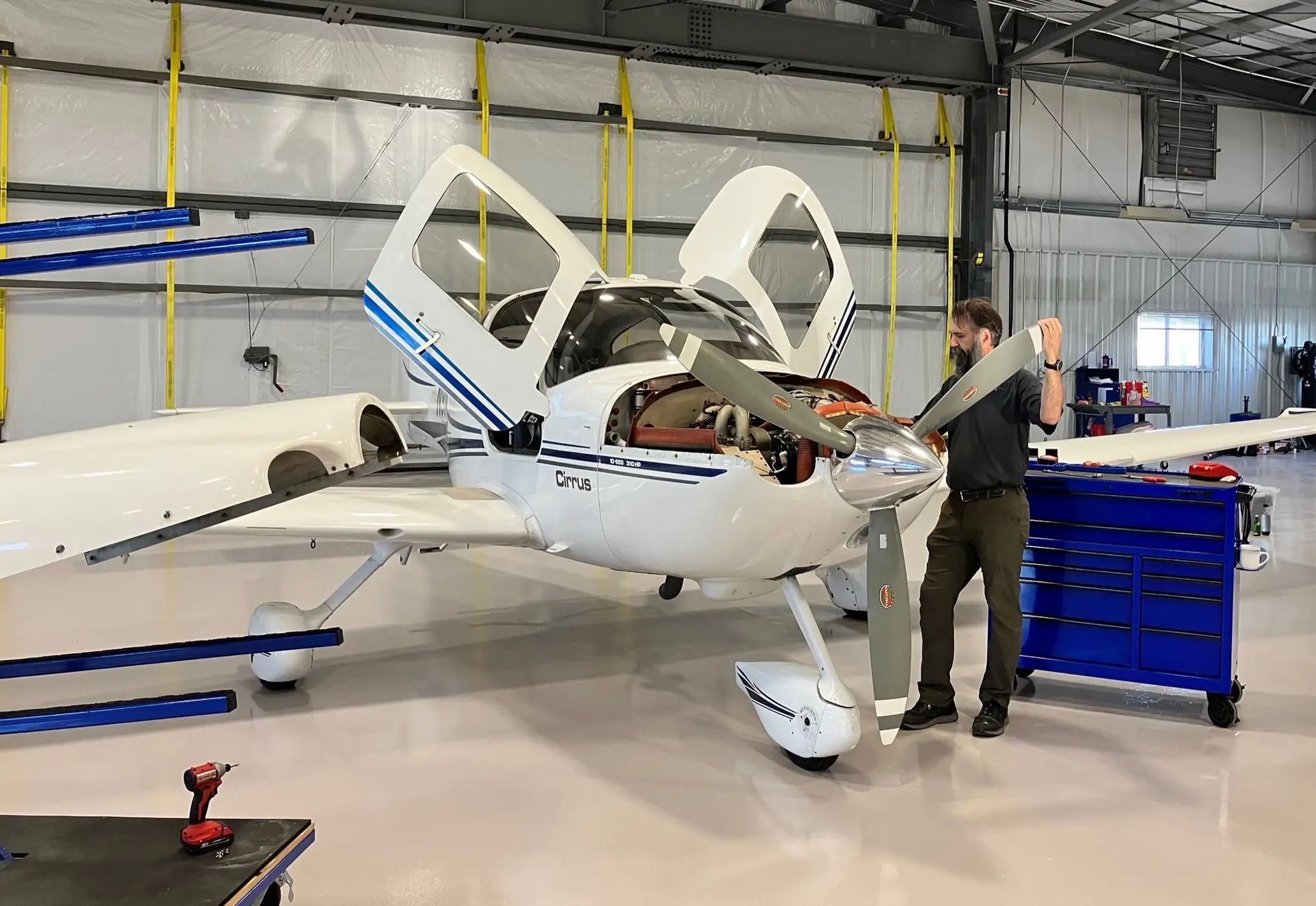 Technician working on a Cirrus aircraft inside the TCA hangar